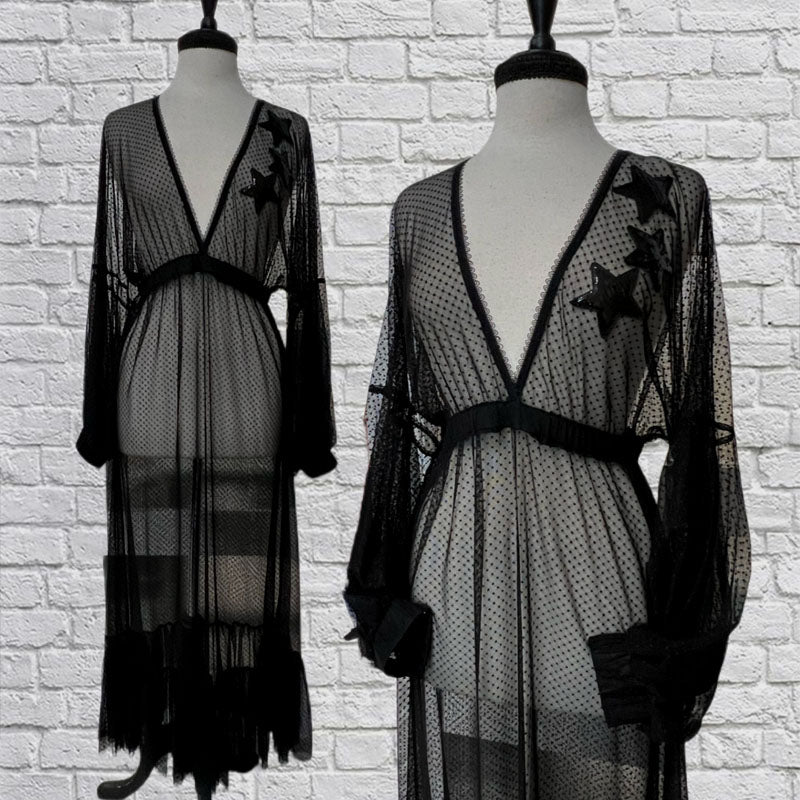 Mannequin forms showing the Jasmine Ceremony dress in mesh Swiss Dot with billowy bishop sleeves, deep V neck, sequin stars on the bodice, an empire waist with gathered under bust, maxi A-line skirt with a ruffled hem.
