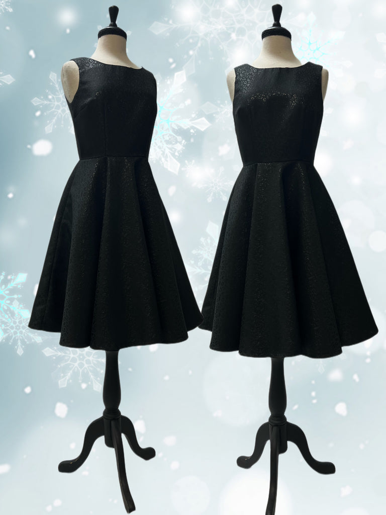 Mannequin form showing the Jenni Dress in all black brocade, with a fitted bodice with Princess seams and a scoop back, circle skirt with side seam pockets, and full lining.