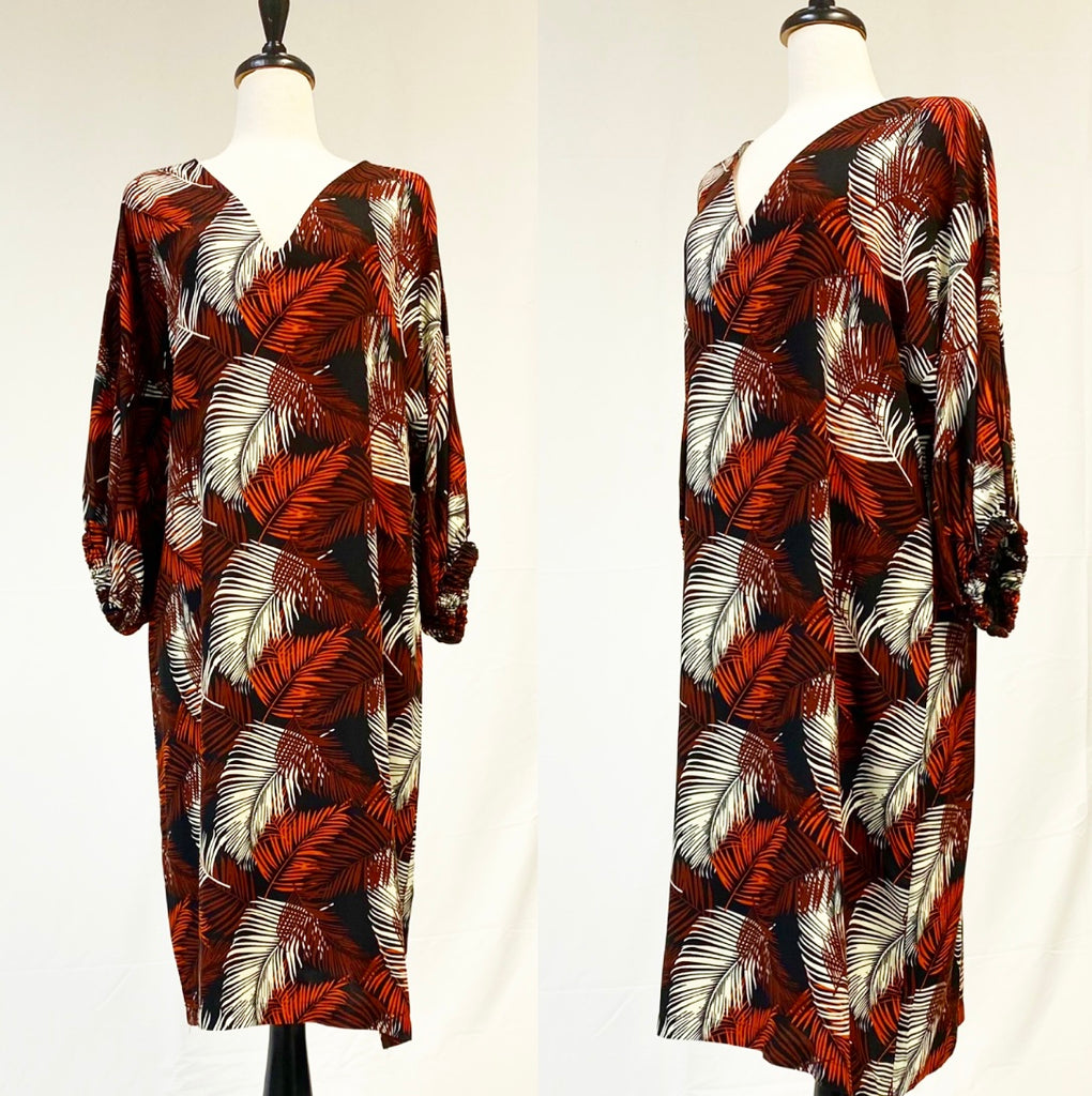 Mannequin forms showing the Camille Dress in a Brown Tropical Print has a V-Neck, balloon sleeves, and a silky rayon fabric