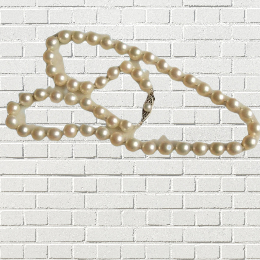 String of pearls against a white brick backdrop.