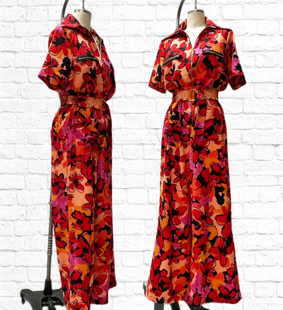 Mannequin form showing the side and front profile of the Frankie Coveralls in floral lightweight pebble crepe. Short sleeves, wide leg pant, front zip closure, belted, front and back patch pockets.