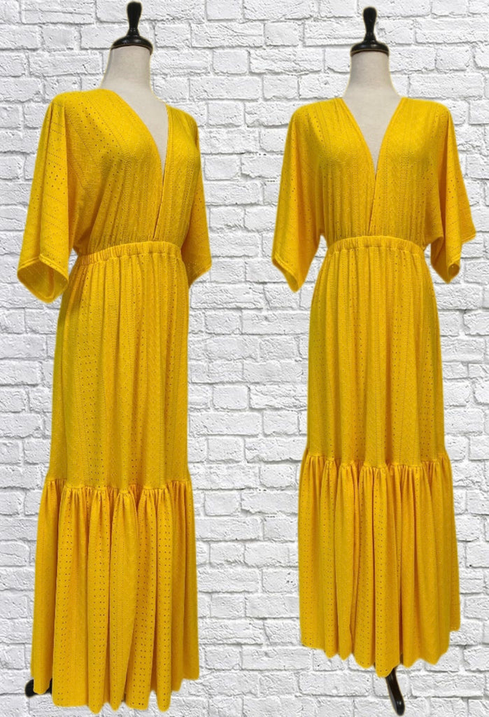 Mannequin forms showing the Jesse Maxi dress in buttery yellow cotton lycra eyelet. Empire waist, kimono style sleeves, and an extra long ruffle hem.