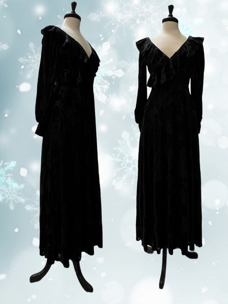 Mannequin forms showing the Penny dress in black on black burnout velvet with long sleeves, V-neck with ruffle detail, and fully lined.