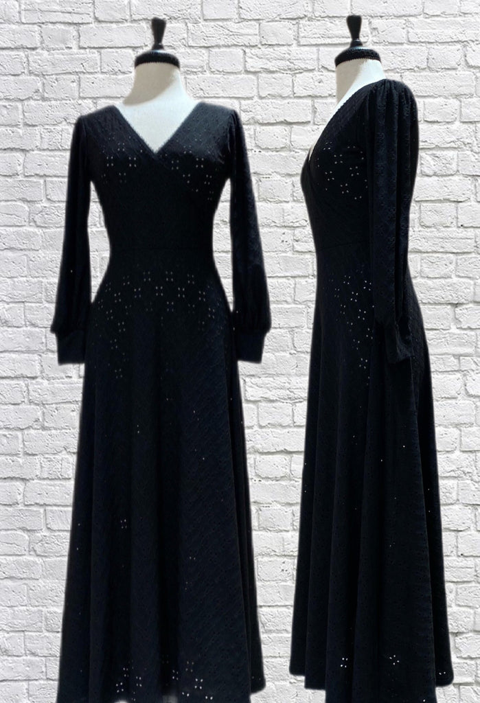 Mannequin forms the Robynne Maxi dress in Black Cotton/Lycra Eyelet with a wrap bodice, maxi A-line skirt, bishop cuffed sleeves