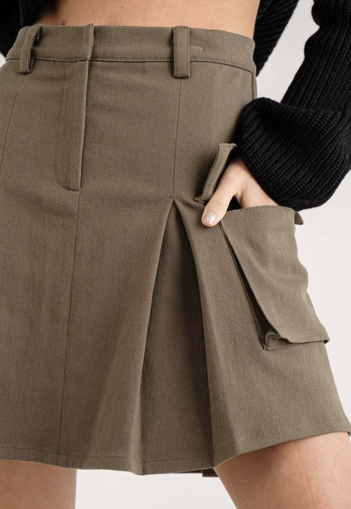 Lower half of a model showing the texture of a A-line cotton twill cargo skirt with side pleats.