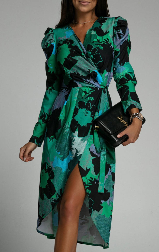 Model wearing a dark green wrap dress in a floral pattern. The dress features long sleeves and puffed shoulders.